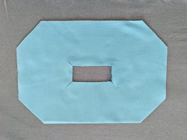 blue fabric with cuts from the corners from the smaller pre-cut square to the points created by the seam ripper.